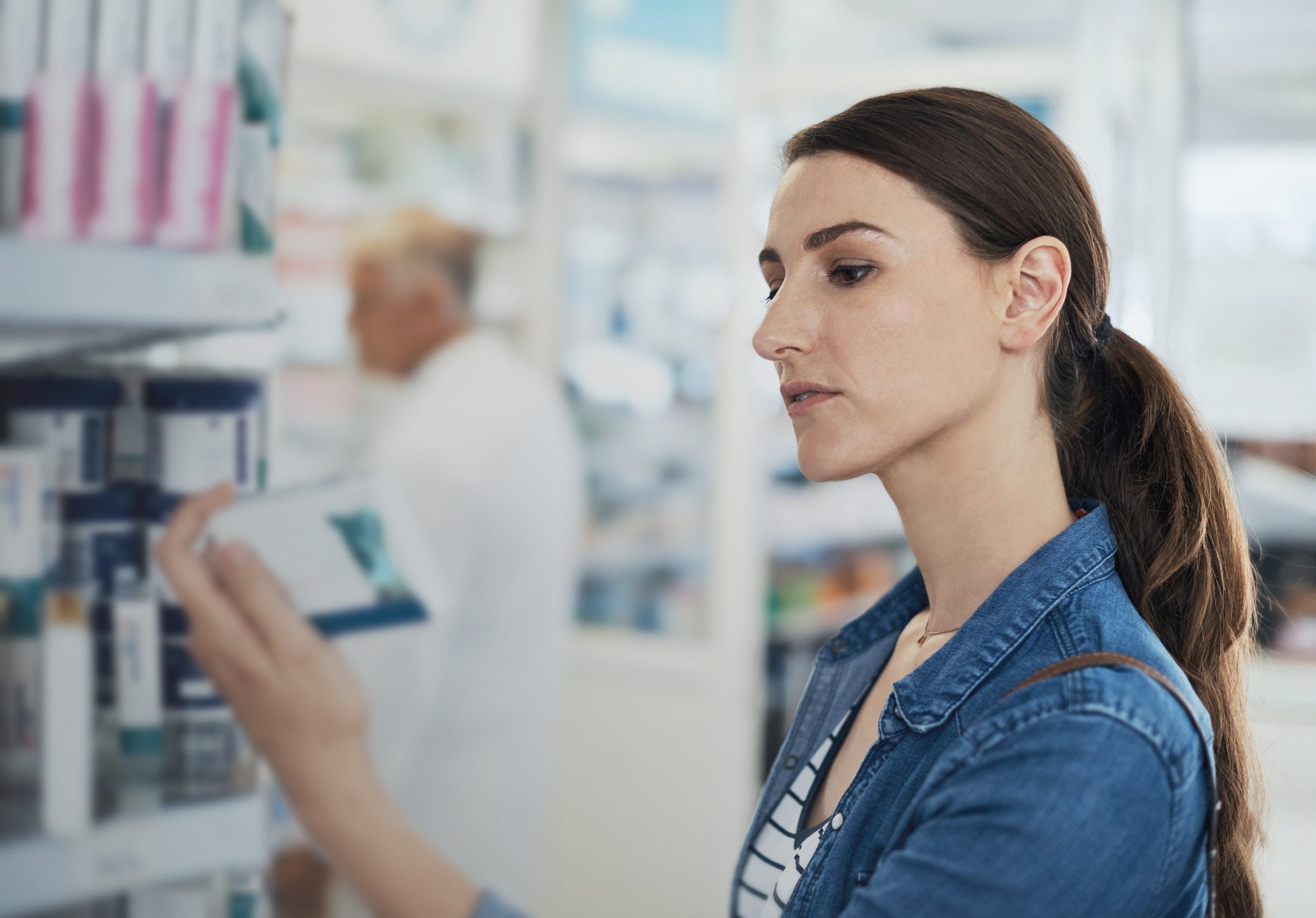 Shot of a young woman browsing the shelves of a pharmacy